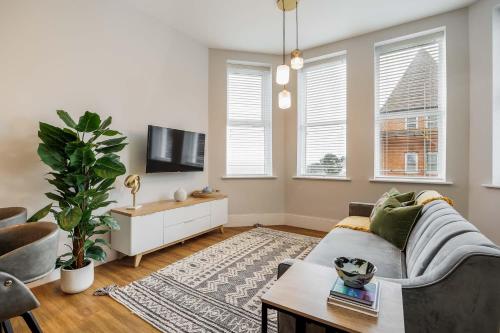 a living room with a couch and a tv at Tower House Apartments in Bournemouth