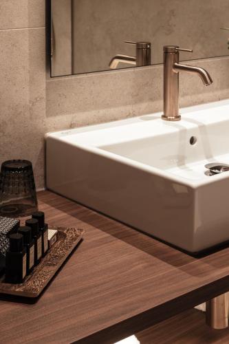 a bathroom with a white sink and a mirror at Hotel Beach Palace by CW Hotel Collection in Blankenberge
