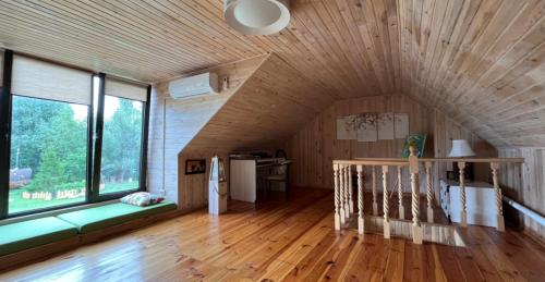 Habitación con techo de madera y ventana grande. en Husky House, en Kladkovka