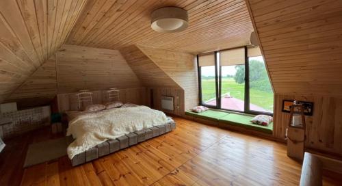 una camera con un grande letto in una stanza con soffitti in legno di Husky House a Kladkovka