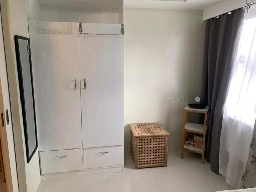 baño con armario blanco grande y taburete en Brenthill Condo (Sandstone Unit), en Baguio