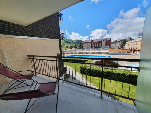 d'un balcon avec une chaise et une piscine. dans l'établissement Vallee Blanche - C2 - Studio pied piste - 4 pers, à Les Deux Alpes