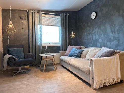 uma sala de estar com um sofá e uma cadeira em Fin sentral leilighet i Lakselv! em Lakselv