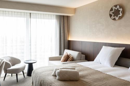 a hotel room with a bed and a chair at Hotel Beach Palace by CW Hotel Collection in Blankenberge