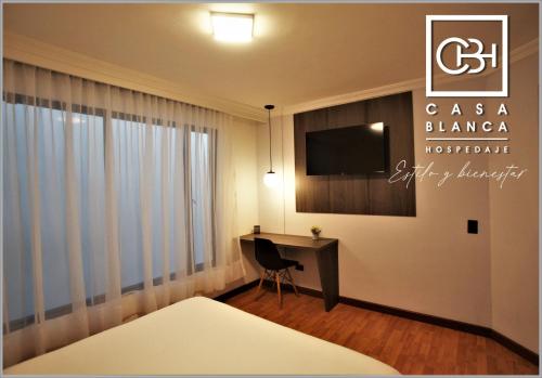 Habitación de hotel con escritorio y TV en Casa Blanca Hospedaje en Pasto
