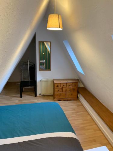 ein Schlafzimmer mit einem blauen Bett und einer Holzkommode in der Unterkunft Appartement Duplex 2a Rue d'Alspach in Colmar