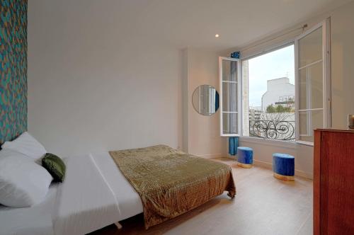 a bedroom with a bed and a large window at Small updated apartment - boulogne in Boulogne-Billancourt