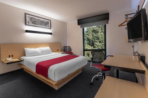 a hotel room with a bed and a desk and a computer at City Express by Marriott Oaxaca in Oaxaca City