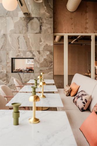 a dining room with tables and chairs and a tv at Strandhotel Zoomers in Castricum