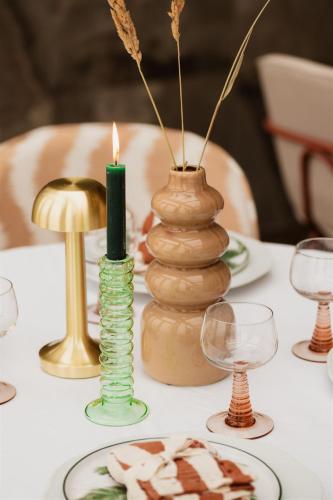 a table with a candle and some vases on it at Strandhotel Zoomers in Castricum