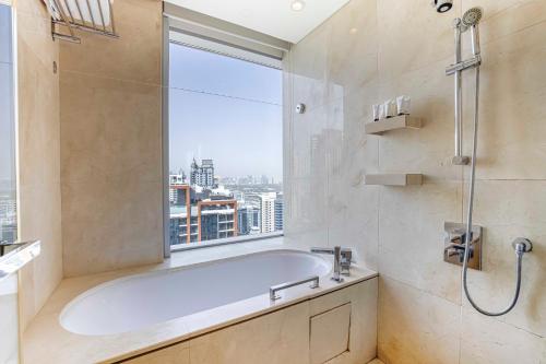 a bathroom with a bath tub and a window at Daniels 1BR at Address Marina High Floor with Marina View in Dubai