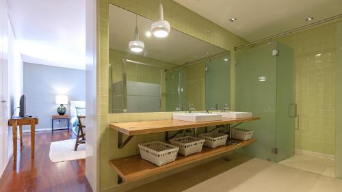 a bathroom with a sink and a large mirror at LovelyStay - Chiado 3Bedroom Wonder in Lisbon