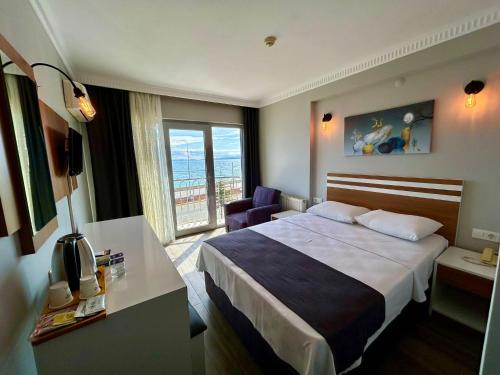 ein Hotelzimmer mit einem Bett und einem Fenster in der Unterkunft Lopera Beach Hotel in Edremit