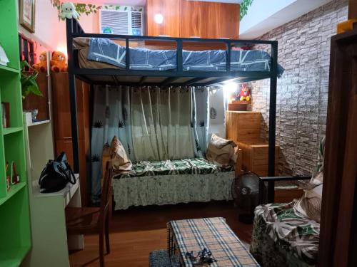 a room with a bunk bed and a couch at Paseo Verde Condominium in Manila