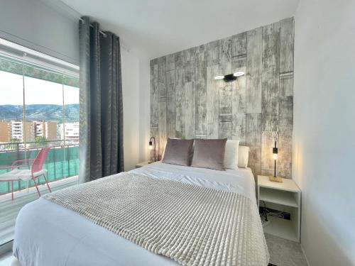ein Schlafzimmer mit einem weißen Bett und einem Fenster in der Unterkunft LaFrenchTouch - Coqueto estudio terraza con vistas in Torremolinos