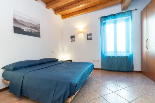 a bedroom with a blue bed and a window at JAM Apartments in Malcesine