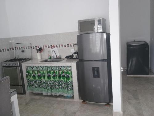 a kitchen with a stainless steel refrigerator and a sink at Alojamiento valerie in Neiva