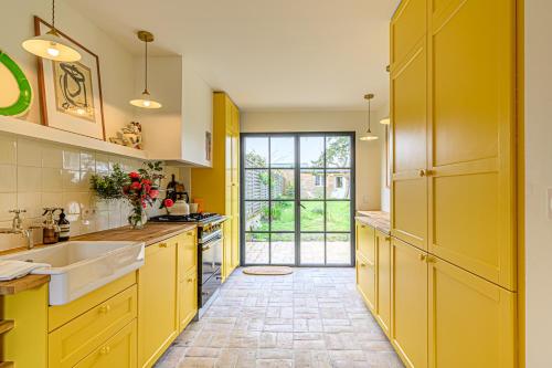 - une cuisine avec des placards jaunes et un évier dans l'établissement Solam - Maison de peintre et de vacances, à Vannes