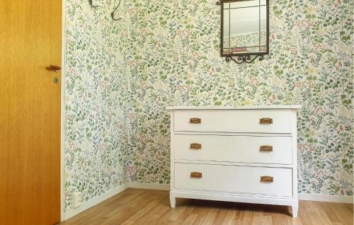 a bedroom with a dresser and floral wallpaper at Cozy Home In Sparreholm With Wifi in Sparreholm