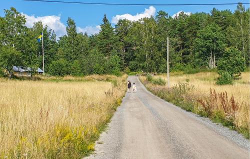 two people walking down a dirt road in a field at Cozy Home In Sparreholm With Wifi in Sparreholm
