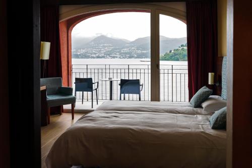 a bedroom with a bed and a view of the water at Il Porticciolo in Laveno-Mombello