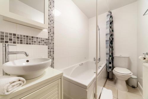 a white bathroom with a sink and a toilet at Couple's getaway 1BDR apt near Holland Park in London