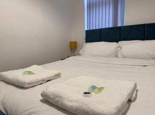 a bedroom with two towels on a bed at Rooms Near Me - Apartment 2, Smart Tv, Free Parking in Halesowen