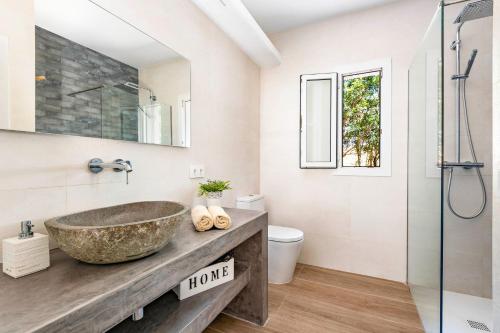 een badkamer met een stenen wastafel en een douche bij Villa Bini Uxuanne by Villa Plus in Binibeca