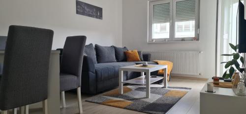 a living room with a blue couch and a table at Apartmani Iva in Banja Koviljača