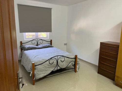 a bedroom with a bed and a window and a dresser at Spacious Flat in Port Louis in Port Louis