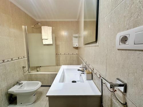 y baño con lavabo, aseo y espejo. en La Sirenuca, en Santoña