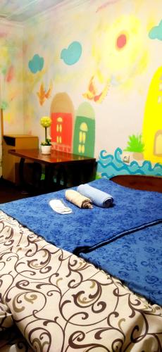 a bedroom with a blue bed with a painting on the wall at Asine Yerevan in Yerevan
