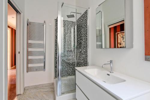 un bagno bianco con lavandino e doccia di Tibullo ,Classico ed Elegante Appartamento a Roma