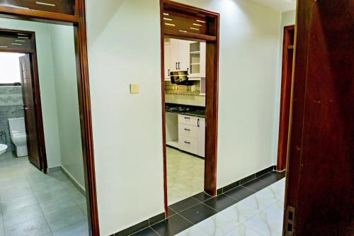 a kitchen with two large mirrors in a room at Crown Elegance Suites in Kampala