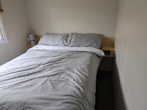 a bed in a small room with a bedskirts at The Hidden Gem in Galloway Forrest in Balminnoch