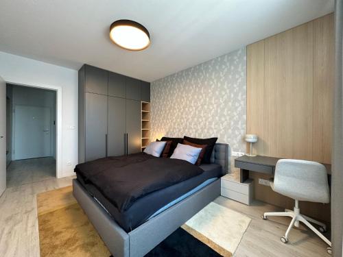 a bedroom with a bed and a desk and a chair at Nivy, parkovanie, blizko centra in Nivy