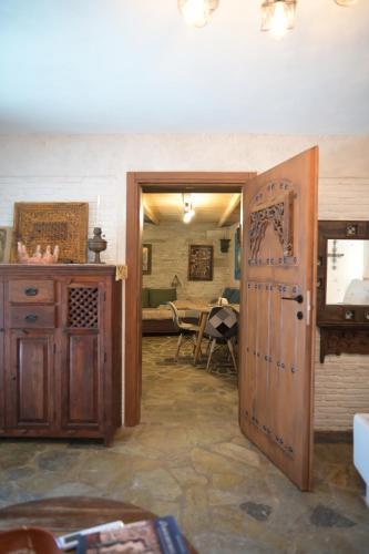 a room with a wooden door and a table at Villa Art Natalie in Kithnos