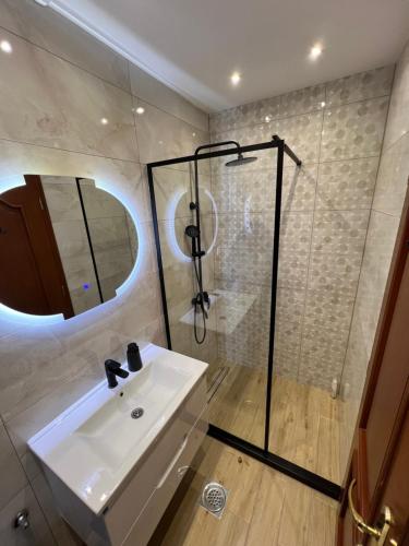 y baño con lavabo y ducha. en Apartmani Central 12 & Free parking, en Vrnjačka Banja