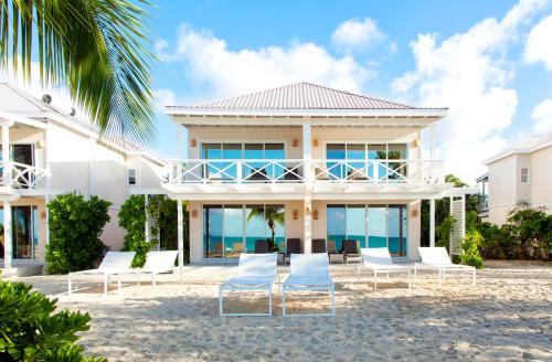 a house on the beach with chairs at Galley Bay Resort & Spa in Saint Johnʼs
