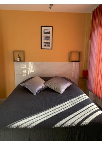a bedroom with a bed with two pillows on it at chez stephane in Pontcarré