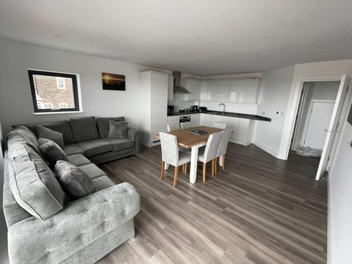 a living room with a couch and a table at Excalibur 3 Bed sleeps 7 in Tintagel