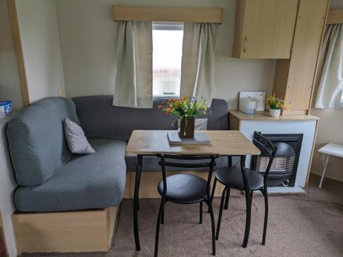 a living room with a table and a couch at The Hidden Gem in Galloway Forrest in Balminnoch