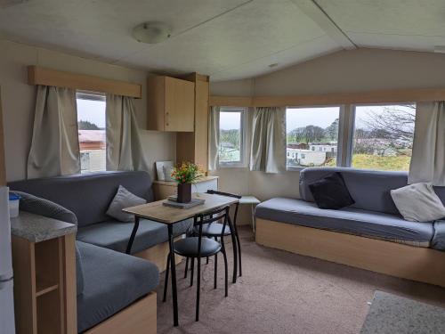 a living room with a couch and a table at The Hidden Gem in Galloway Forrest in Balminnoch