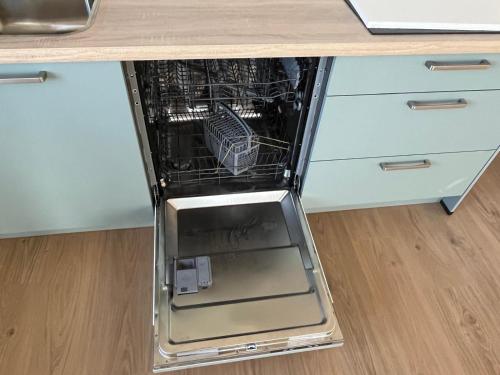a dishwasher with its door open in a kitchen at Residentie Oosterschelde in Sint Philipsland