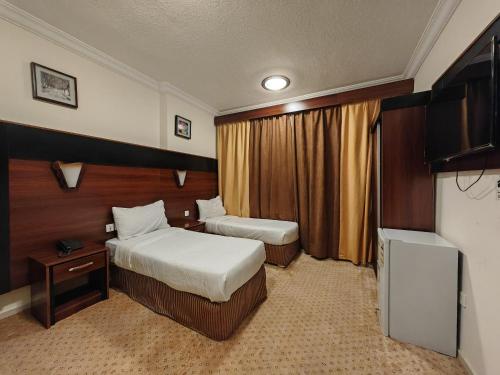 a hotel room with two beds and a television at فندق ميزاب العدل مكة in Makkah
