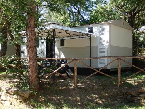 a small white trailer with a tree in front of it at Camping Village la Chiocciola in Capannole