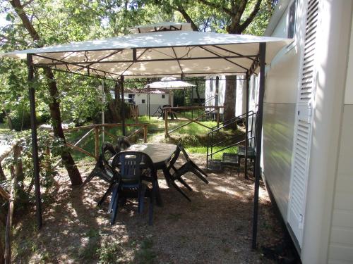 a patio with a table and chairs under a canopy at Camping Village la Chiocciola in Capannole