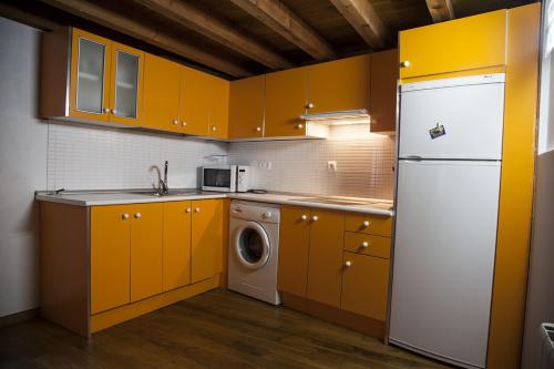 cocina con armarios amarillos y nevera blanca en Duplex en Casco Histórico, en Toledo