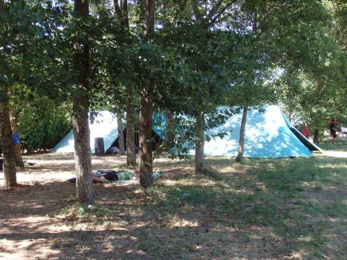 a person laying on the ground in front of a tent at Camping Village la Chiocciola in Capannole