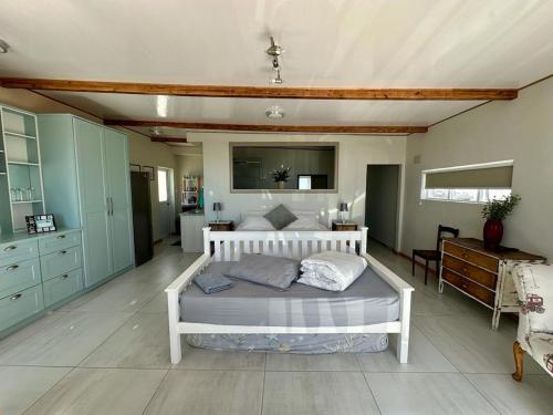 a bedroom with a white bed in a room at Blue Bay Studio Bayview in Cape Town